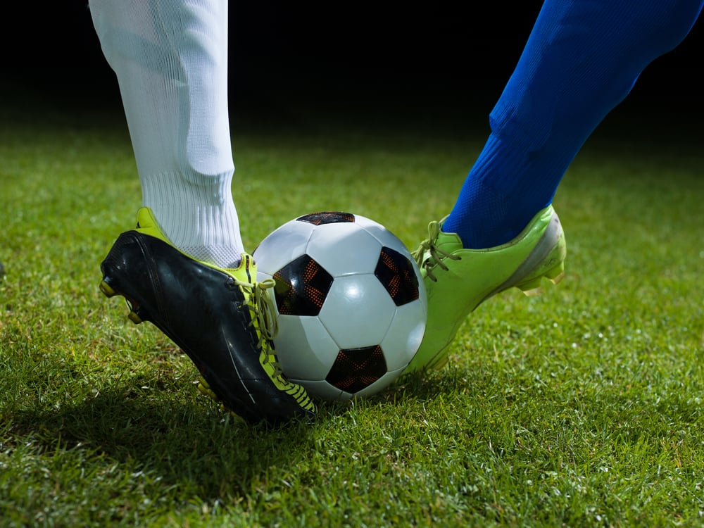 soccer player doing kick with ball on football stadium  field  isolated on black background